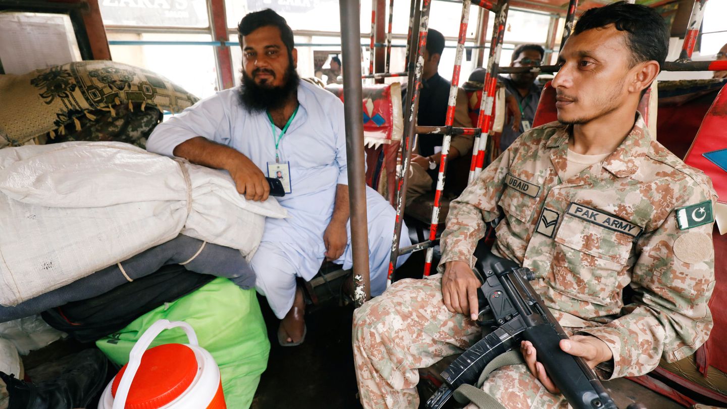 Un soldado y un funcionario distribuyen material electoral en una furgoneta en Karachi, el 24 de julio de 2018. (Reuters)