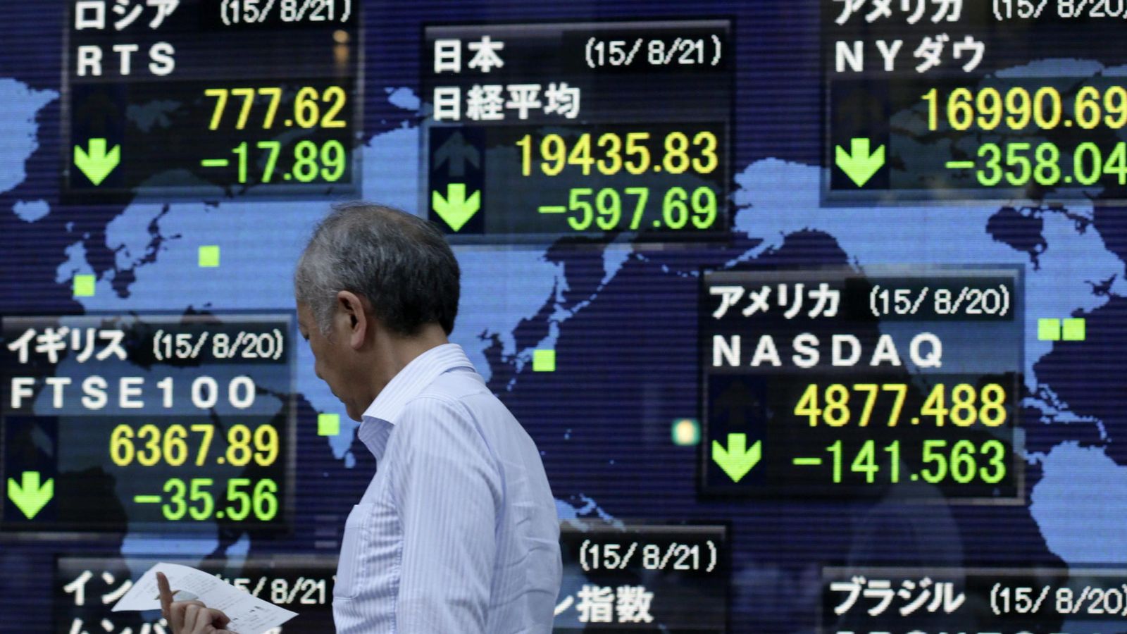 Foto: Un viandante pasa delante de una pantalla que muestra información bursátil en Tokio. (EFE)