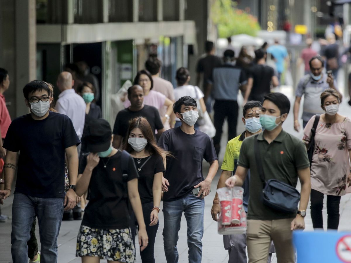 Foto: Ciudadanos de Singapur, paseando por una céntrica calle el mismo día en que se decreta el 'circuit breaker'. (Reuters)